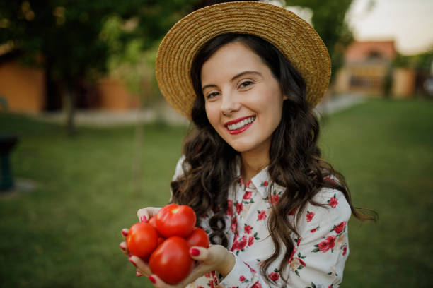 istock Young beautiful female farm worker picking ripe tomatoes 1363444881