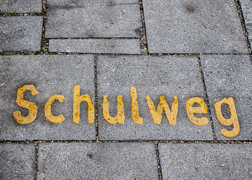 Writing on a road with concrete tiles telling this is a school road in Unterschleissheim a suburb to the German city Munich which is the capital city in Bavaria