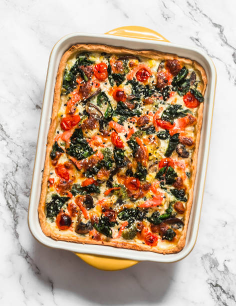 istock Savory pie with salmon, mushrooms, vegetables, spinach and cheese in a baking dish on a light background 1363451931