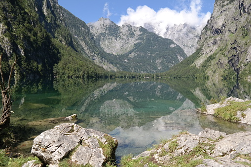 Alpine lake surrounded by mountains. Smooth water with reflections.