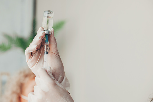 Manos del médico sosteniendo una jeringa con la vacuna contra el coronavirus. Vacunación Covid-19. Tratamiento médico. Protección antivirus. photo