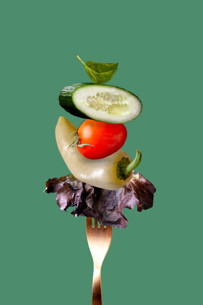 istock vegetables for preparing salad on a golden fork on a green background 1363460579