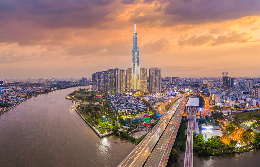 Ho Chi Minh city, Vietnam, 08 Jan 2022: Aerial sunset view at Landmark 81 - it is a super tall skyscraper and Saigon bridge with development buildings along Saigon river light smooth down