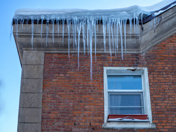 istock Large winter icicles hanging from the house roof 1363465752