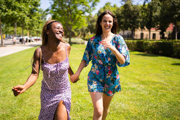 istock Two multiethnic women having fun while running holding hands outdoors 1363469475