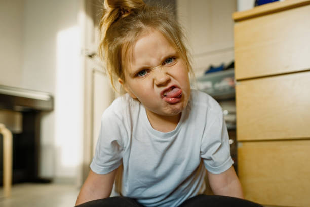 istock Girl 3-year old at home grimaces, makes faces 1363469609