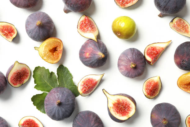 istock Tasty fresh purple and green figs on white table, flat lay 1363469615