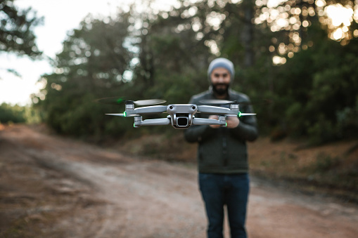 Man pilot is flying drone with remote control