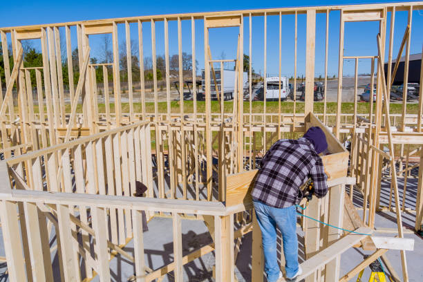 istock Aerial top view of a worker in white protective gloves holding plank installing it on household construction using air hammer in nailing wooden beams. 1363473043