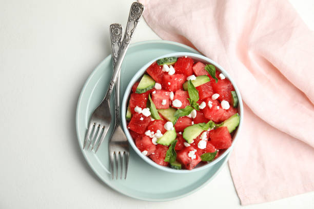 istock Delicious salad with watermelon, cucumber and cheese on white table, flat lay 1363473372