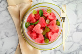 Delicious salad with watermelon on white marble table, flat lay