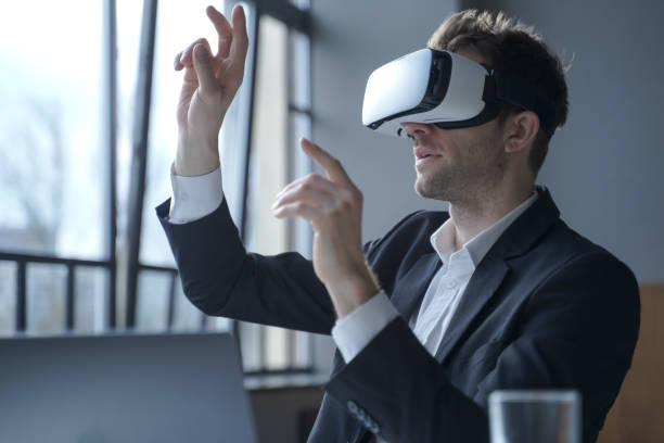 istock Excited man office worker wearing vr goggles touching objects with hands in digital world 1363475384