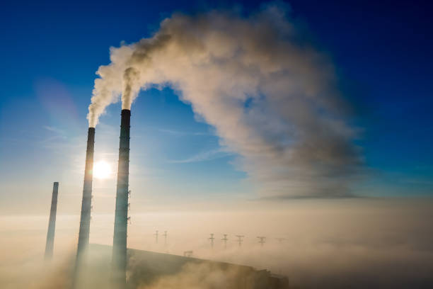 vista aérea de canos altos de usinas de carvão com fumaça preta subindo a atmosfera poluidora ao pôr do sol. - rasto de fumo de avião - fotografias e filmes do acervo