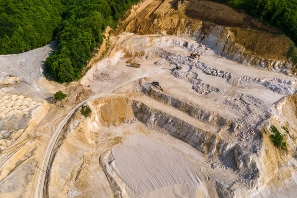 istock Open pit mining of construction sand stone materials with excavators and dump trucks. 1363475639