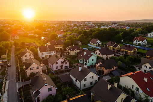 Aerial view of residential houses in suburban rural area at sunset.
