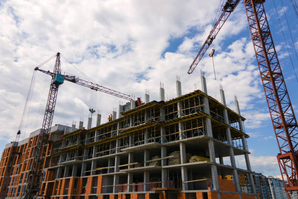 istock Tower crane at high concrete residential building under construction. Real estate development concept. 1363475680