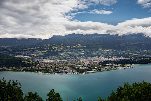 Color landscape photography of a high angle view over Bourget Lake and cities around. This image was taken on Bourget Lake riverbanks, near Aix-Les-Bains famous thermal station city in Savoie, Auvergne-Rhone-Alpes region in France, Europe.