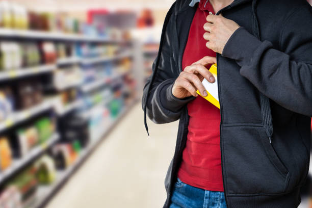 vol à l’étalage au détail. un homme qui vole dans un supermarché - thief photos et images de collection