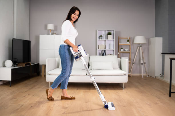 jeune femme de ménage nettoyage du sol - vacuum cleaner photos et images de collection