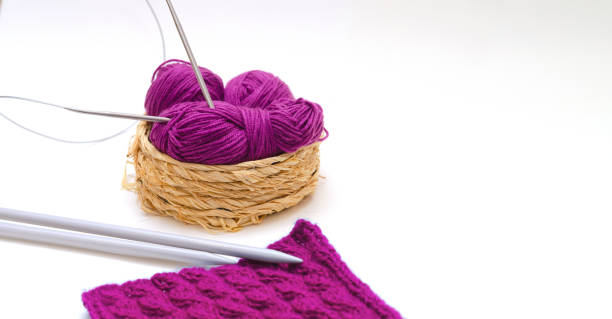 istock Balls of colored knitting threads and knitting needles on a white background 1363483033