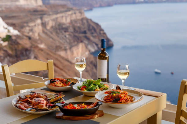 Dinner for two in a restaurant overlooking the sea Dinner for two in a restaurant overlooking the sea and the island of Santorini, Greece santorin stock pictures, royalty-free photos & images