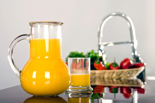 Close up pitcher of orange juice on kitchen table in modern domestic kitchen