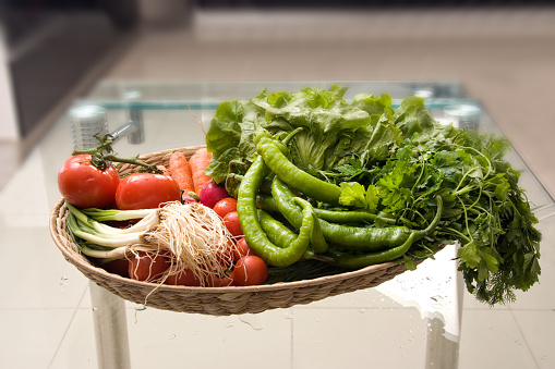 Close up bowl of vegetables on glass table in modern domestic kitchen