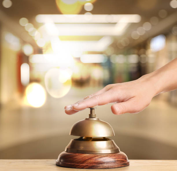 istock Woman ringing hotel service bell on blurred background, closeup 1363488731
