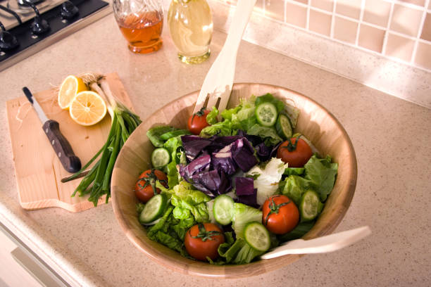 Bowl of fresh green salad on domestic kitchen counter