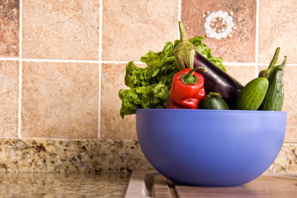 Close up bowl of fresh vegetables on rustic domestic kitchen counter