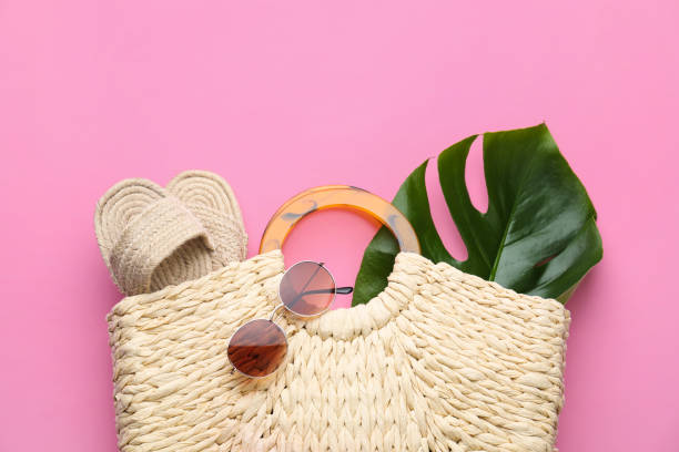 bolsa de palha elegante da mulher com sapatos, folha tropical e óculos de sol no fundo rosa, vista para cima - bolsa de praia - fotografias e filmes do acervo