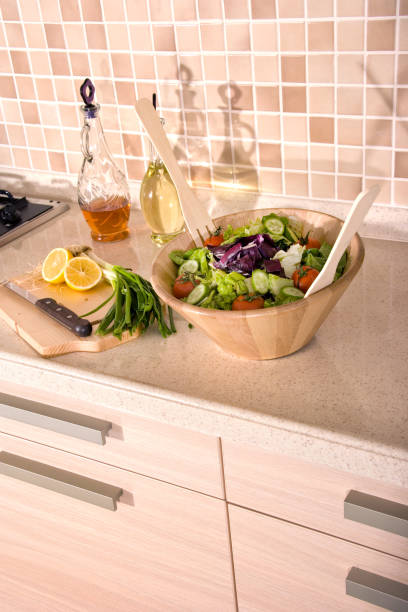 Bowl of fresh green salad on domestic kitchen counter