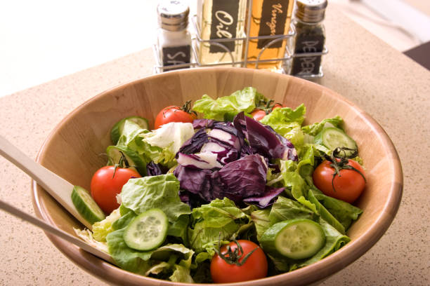 Bowl of fresh green salad on domestic kitchen counter