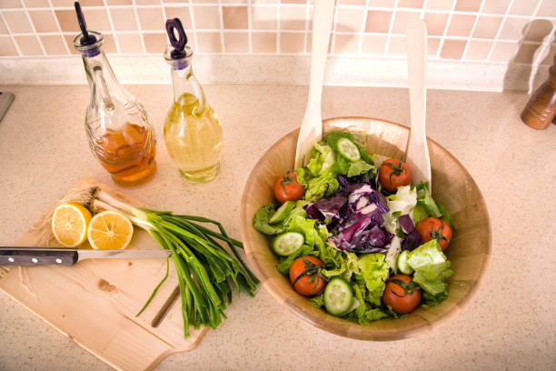 Bowl of fresh green salad on domestic kitchen counter
