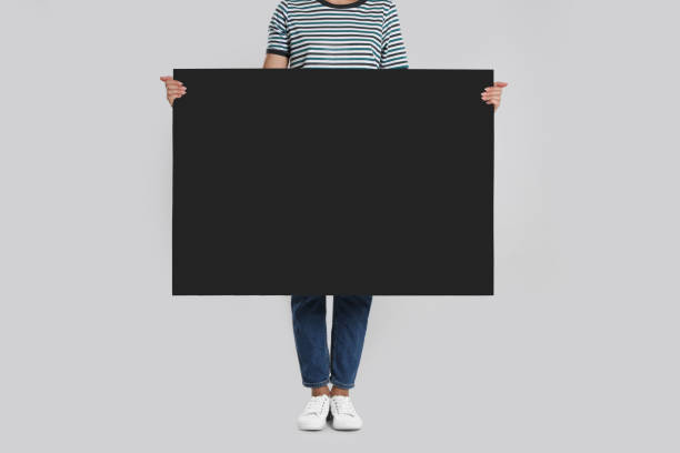 istock Woman holding blank poster on light grey background, closeup 1363488971
