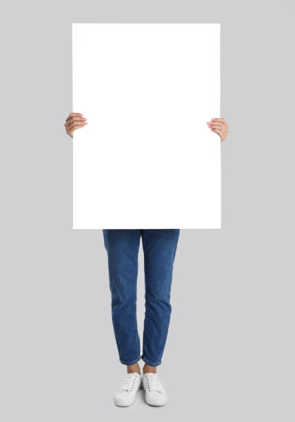 istock Woman holding blank poster on light grey background 1363488973