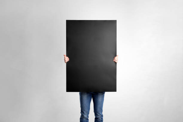 Man holding blank poster on light grey background