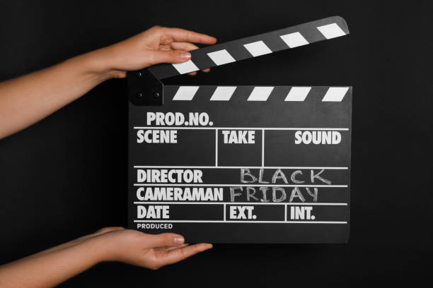 istock Woman with clapperboard against dark background, closeup. Black Friday concept 1363489085