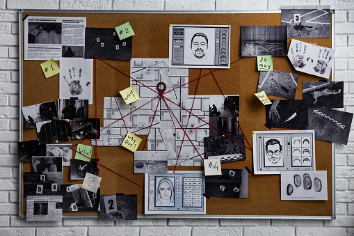 Detective board with fingerprints, photos, map and clues connected by red string on white brick wall