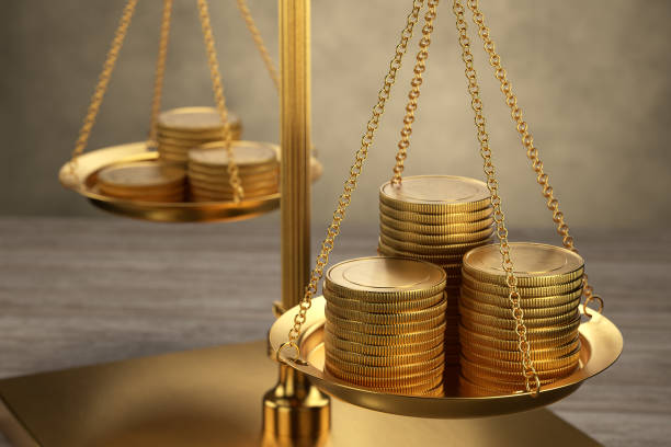 istock stacks of bright new shiny gold coins placed on scales. 3d render 1363490214