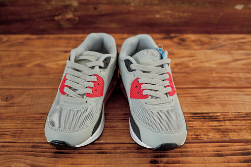 Low budged sneakers on wood background, close-up, no people