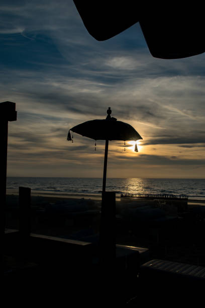 istock beach unbrella at sunset 1363499964