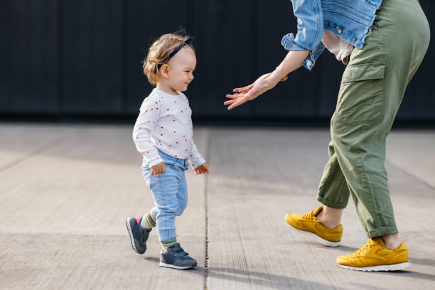 istock Cute Young Girl Walking Outdoors Towards Her Anonymous Mother 1363504967