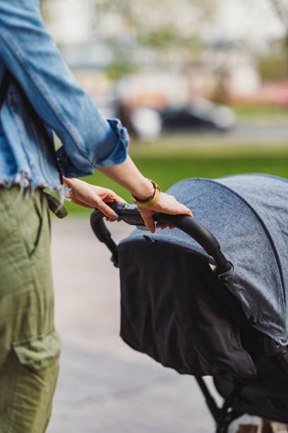 istock Anonymous Woman Pushing a Stroller n the Park 1363505005