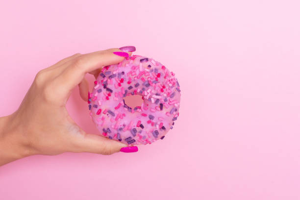 istock Female hand holding donut 1363505158