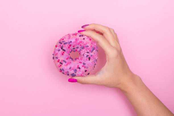 istock Female hand holding donut 1363505159