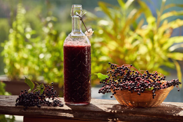 istock Black elder syrup and fresh elderberries outdoors - natural herbal remedy 1363506731