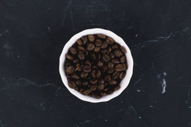 istock Coffee beans in a white plate on a black background. 1363517812