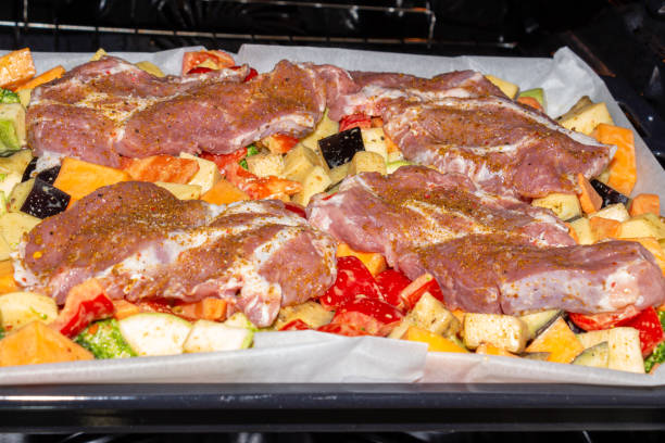 istock Finely chopped and seasoned vegetables with pork, placed on a baking sheet, before baking on parchment in the oven. Potatoes, bell peppers, squash, pumpkin and broccoli. Close-up 1363522556