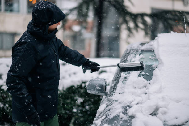 istock Middle aged man cleaning car from snow and ice 1363522654